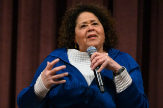 Woman with microphone, mid gesture.