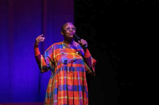 On stage with bright orange, blue and yellow dress.