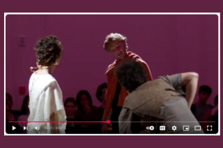 Screengrab from a YouTube video. Three actors, one in a toga. 