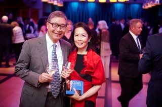 Two guests, man and woman in semi-formal attire, enjoying the Yale Schwarzman Center opening celebration