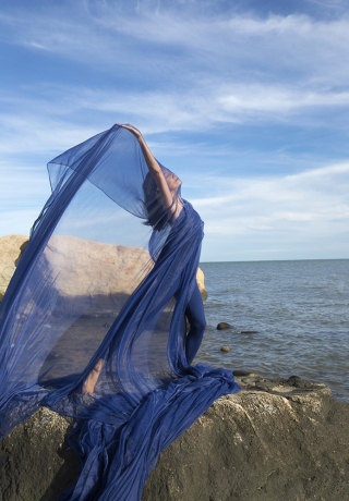 Dance in a field of green with blue sky and flowing blue dress