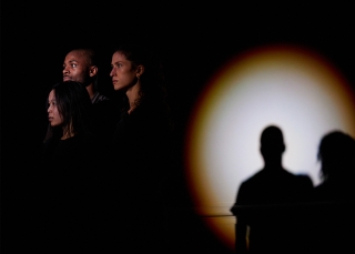 Three dancers still in spotlight. 