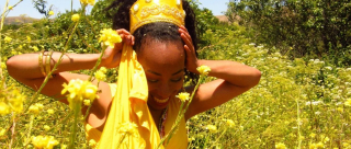 Smiling in sunny field of flowers.