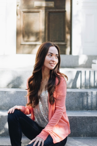 Hannah sitting outdoors, with a pink top.