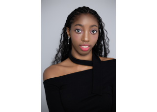 Headshot. Black off the shoulder top. Grey backdrop.